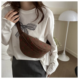 Detail of strawberry embroidery texture on brown corduroy crossbody chest bag