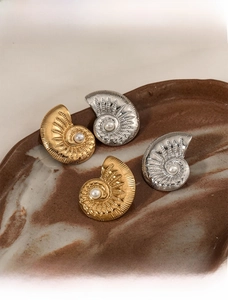 Detail of vintage French shell earrings with pearls on a rustic ceramic tray