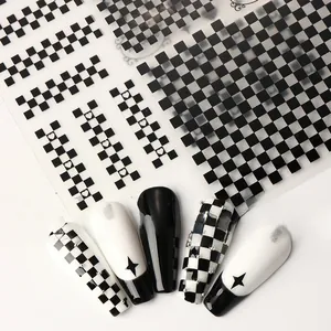Detail of checkerboard nail stickers with heart designs and silver bead accents