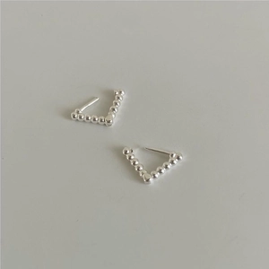 Detailed close-up of 925 sterling silver geometric triangle bead studs on a gray surface