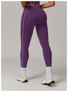 Detalle de pantalones de yoga morados de talle alto con rayas blancas y ajuste ceñido