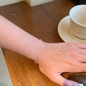 Macro detail of minimalist S925 sterling silver heart bracelet on a female wrist