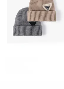 Detail of ribbed knit beanies with HAPPY patch in gray and khaki colors