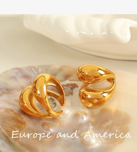 Detail view of 18K gold plated titanium steel rings with fluid teardrop design on shell