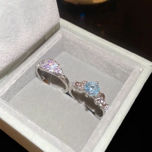 Macro detail of silver rings with sparkling zircon floral accents and sky blue gemstone