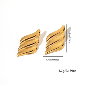 Macro shot of gold wave earrings showing dimensions of 2cm by 1.7cm and metallic texture
