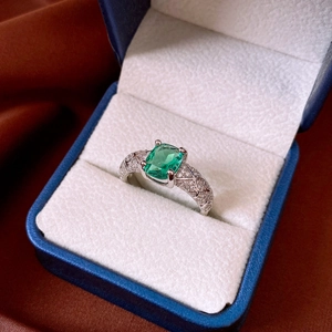 Dettaglio macro di un anello con gemma verde taglio smeraldo in astuccio di velluto blu