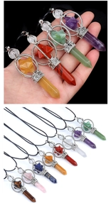 Detail of natural crystal hexagonal pillar pendants with ornate silver-toned metal caps