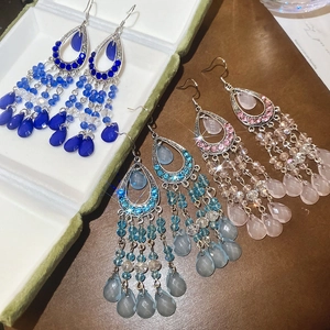 Detailed close-up of vintage style drop earrings with crystal tassels and colorful glass