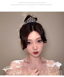 Close-up of sparkling silver rhinestone tiara with heart pattern and elegant bridal details