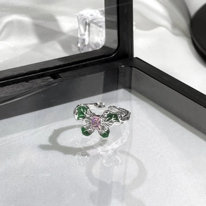 Detail of a silver butterfly ring with green enamel wings and a pink gemstone