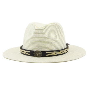 Detailed close-up of straw Fedora hat with western bull head metal buckle and cord