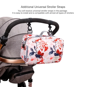 Florale Kinderwagentasche mit Universal-Gurten am grauen Kinderwagengriff befestigt