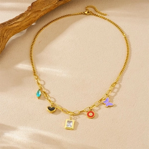 Collier à maillons dorés avec breloques colorées cœur et papillon sur fond beige texturé