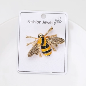 Macro shot of yellow enamel bee brooch with sparkling rhinestones on jewelry card