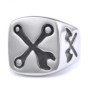 Polished stainless steel wrench ring with industrial cross-wrench design on white background