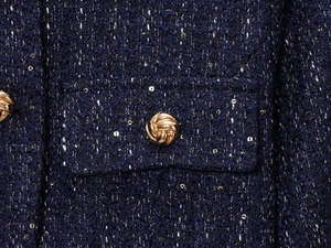 Detailansicht der dunkelblauen Tweed-Jacke mit goldenen Pailletten und Metallknopf