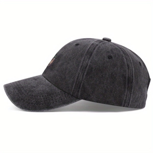 Detail view of washed cotton fabric texture and 6-panel structure on dark grey baseball cap