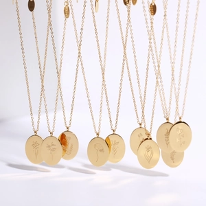 Detailed macro view of 18K gold plated oval pendants with engraved floral designs