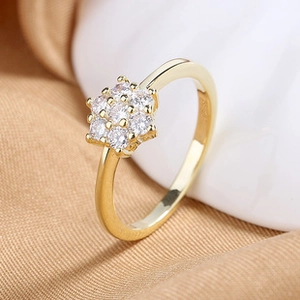 Macro shot of gold-plated ring featuring a hexagonal flower-shaped zircon prong setting