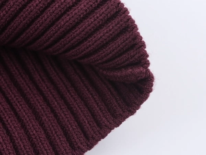 Close-up of chunky ribbed knit texture in deep burgundy yarn showing fabric details