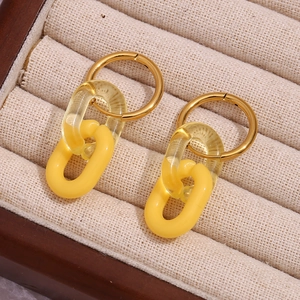 Vista macro di orecchini a cerchio placcati oro 18K con maglie in acrilico giallo brillante