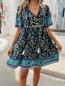 Detail view of Bohemian floral print mini dress with V-neckline and tassel drawstrings