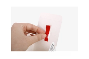 Detail showing the ribbon threading process for the house-shaped gift box assembly