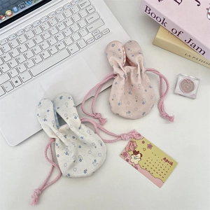Close-up of cute floral drawstring bags with bunny ears in pink and off-white colors