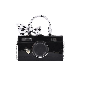 Fashionable black camera-shaped crossbody bag with polka dot ribbon handle and metal chain
