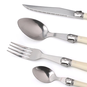 Detailed view of stainless steel cutlery set with cream handles and Laguiole bee motif