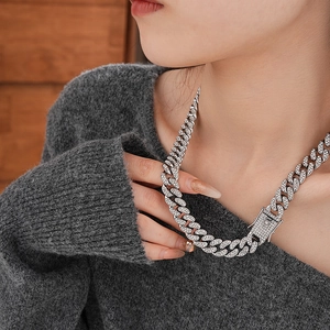 Detail of silver Cuban link necklace with sparkling rhinestones worn by a model