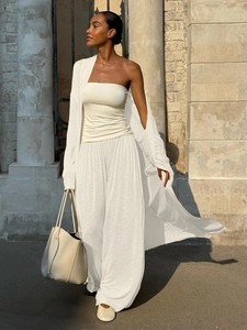 Detail of white linen knit three-piece set showing textured fabric and fluid drape