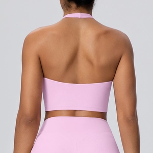 Vista posteriore del top da yoga allacciato al collo rosa chiaro e leggings alti