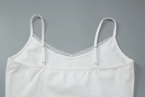 Close-up detail of white lace trim V-neckline and adjustable straps on camisole top