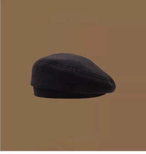Detail view of the black retro beret with brand logo texture and fall-winter 2021 series labels