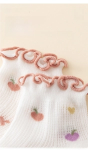 Detailed macro view of pink ruffle trim and breathable jacquard patterns on baby socks