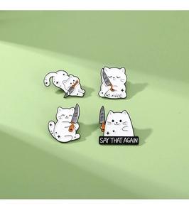 Set of four funny white cat enamel pins with knives displayed on green background
