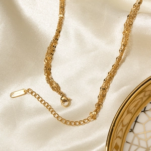 Macro shot of 18K gold plated triple layered stainless steel necklace with S.Steel engraving