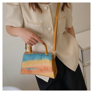 Detail of gradient crossbody bag with textured faux leather and gold metal hardware