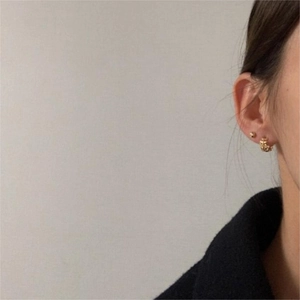 Détail de boucles d'oreilles en argent 925 avec texture tissée et puce d'oreille dorée