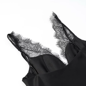 Détail du haut en satin noir avec bordure en dentelle délicate et fines bretelles