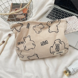 Close-up of beige corduroy pouch with cute bear prints for makeup and accessories