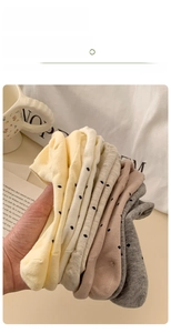 Detailed pile of colorful polka dot low cut cotton socks made with soft combed yarn fabric