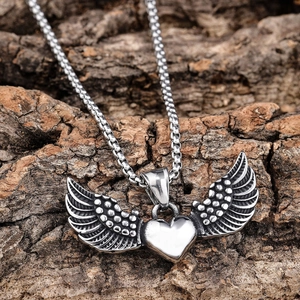 Gothic stainless steel heart pendant with wings on a ball chain over bark background