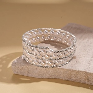 Macro shot of multi-layer spiral cuff bracelet with pearls and rhinestones on stone