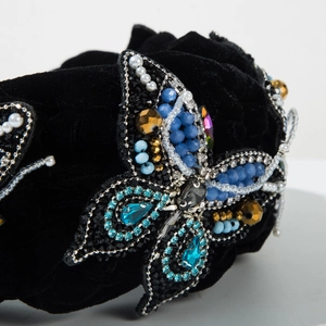 Close-up of velvet headband featuring handcrafted butterfly with crystals and pearls