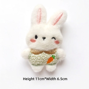 Detail view of plush rabbit accessory with carrot embroidery, size 11cm by 6.5cm