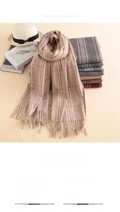 Stack of thick checkered cashmere scarves with tassels in classic British plaid style