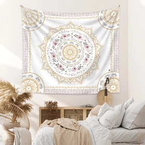 Detail of bohemian mandala tapestry featuring gold patterns and pink flowers in bedroom